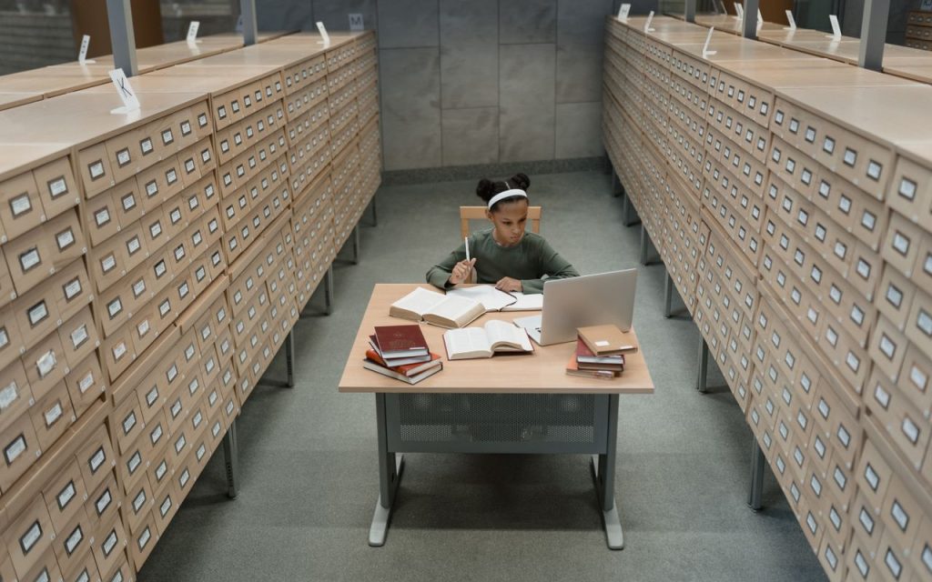 Pessoa consultando livros e fontes de pesquisa