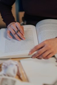 Pessoa lendo e fazendo anotações em um caderno